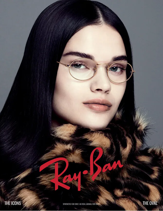 Ray-Banの細いゴールドフレームのメガネをかけた、クールな雰囲気の女性のイメージビジュアル
